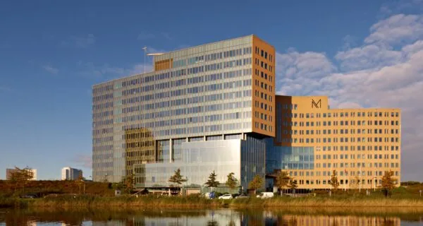 Modern kantoorgebouw aan de Fascinatio Boulevard in Capelle aan den IJssel, weerspiegeld in het water.